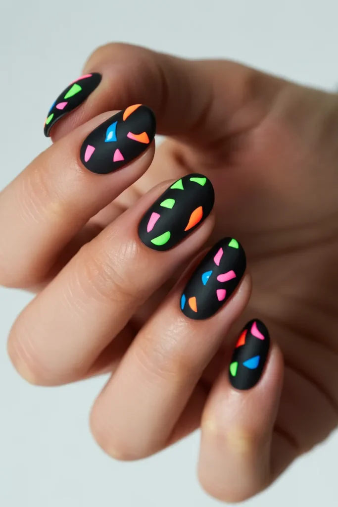 Black nails with bright neon confetti pieces