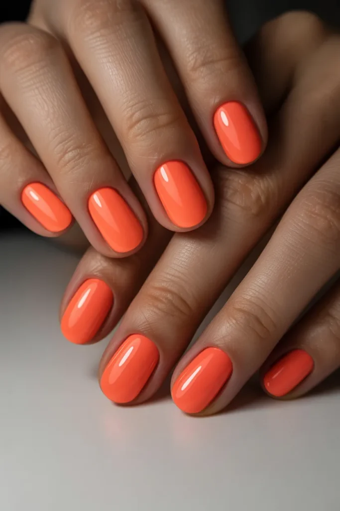 Bright coral nails with glossy finish