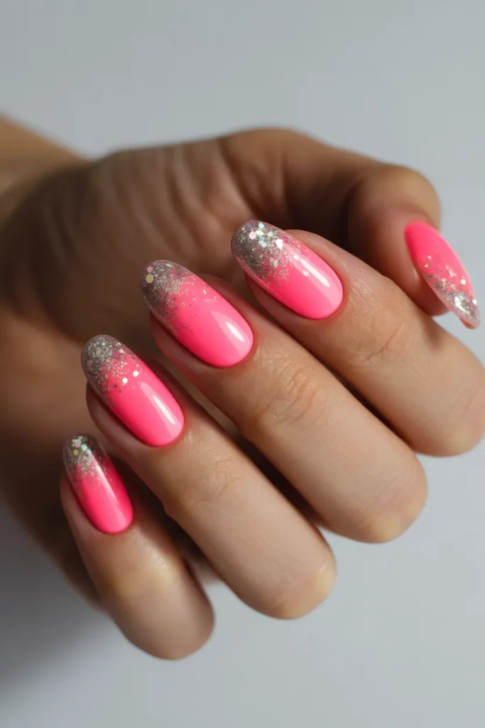 Neon pink nails fading into glitter tips