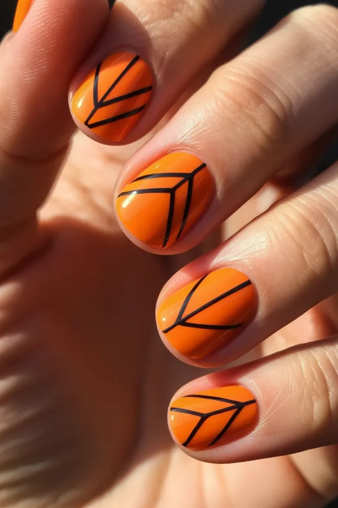 Orange nails with geometric shapes and lines
