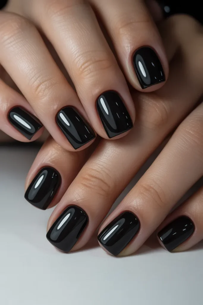 Short square nails painted in high-gloss jet black